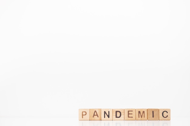 Pandemic word is written on wooden cubes on a white background Closeup of wooden elements