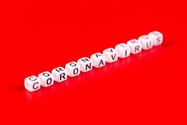 Pandemie en virusconcept - Coronaviruswoord dat van witte blokken wordt gemaakt. Coronavirus tekst op rode achtergrond.