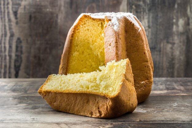 Pandoro Christmas cake with sugar on wooden table