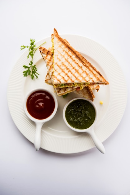 Paneer bhurji sandwich is een smakelijk gerecht op basis van paneer gemaakt met kwark. Geserveerd met verse tomatenketchup en groene muntchutney. selectieve focus