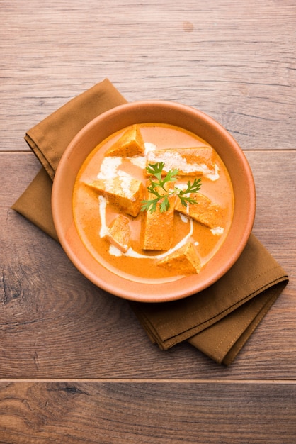 Paneer Butter Masala also known as Panir  makhani or makhanwala. served in a ceramic or terracotta bowl with fresh cream and coriander.selective focus