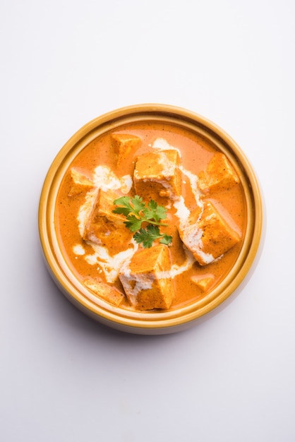 Paneer Butter Masala, также известный как Panir makhani или makhanwala. подается в керамической или терракотовой посуде со свежими сливками и кориандром. выборочный фокус