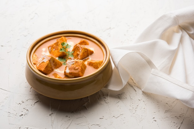 Paneer Butter Masala also known as Panir  makhani or makhanwala. served in a ceramic or terracotta bowl with fresh cream and coriander.selective focus