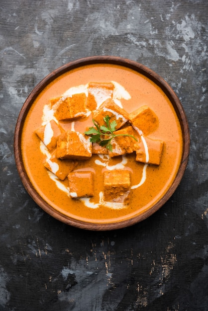 Paneer Butter Masala, также известный как Panir makhani или makhanwala. подается в керамической или терракотовой посуде со свежими сливками и кориандром. выборочный фокус