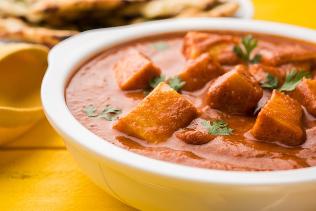 Photo paneer butter masala or cheese cottage curry, popular indian lunch and dinner menu  served in karahi with naan or roti over moody background, selective focus