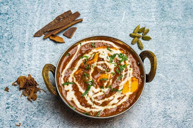 Paneer chicken masala or murgh makhani served in a karahi isolated on grey background top view of bangladesh food