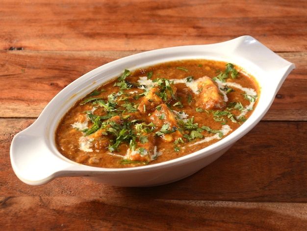 Paneer Masala is een beroemd Indiaas gerecht geserveerd op een rustieke houten achtergrond selectieve focus