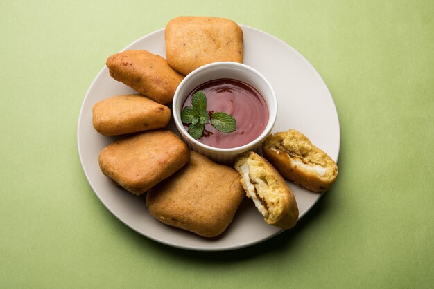 Paneer pakoras of Bhajji zijn grammeel of besan beslag gecoate pittige kwarkblokjes. Geserveerd met tomatenketchup in een bord over kleurrijke of houten achtergrond. Selectieve focus