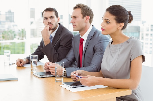 Panel of corporate personnel officers sitting in office