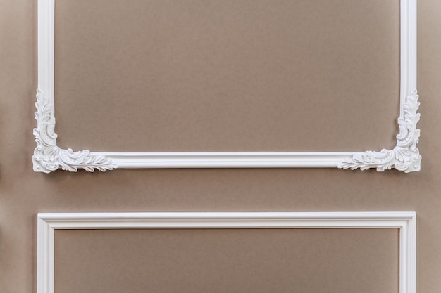 Il pannello è una cornice in gesso con angoli modellati sulla parete della stanza interior design loft con elementi barocchi tonalità beigemarrone