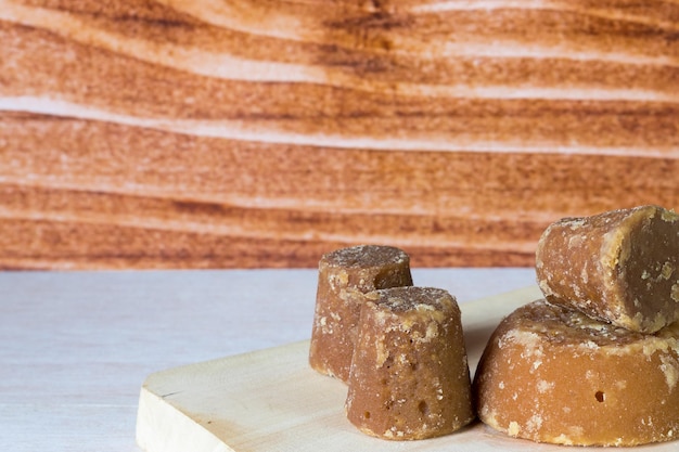 Panela cubes or sweet sugar cane with wooden background typical food of Colombia