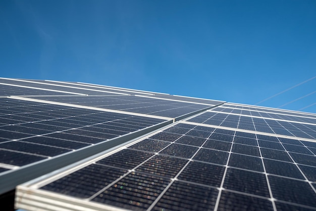 Фото Панели солнечных возобновляемых экономичных батарей на фоне голубого неба