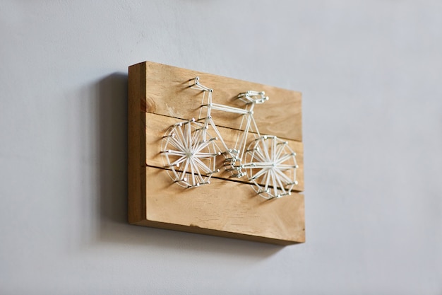 Panels in the style of string art, a bicycle on wooden boards