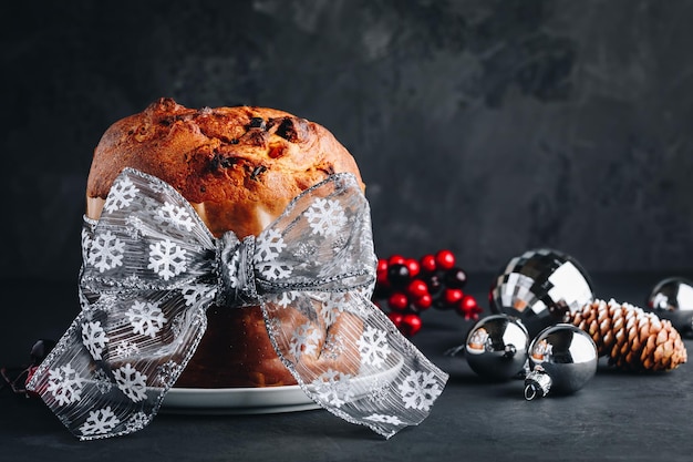 Photo panettone cake traditional italian christmas cake with dried fruits on dark stone background with copy space