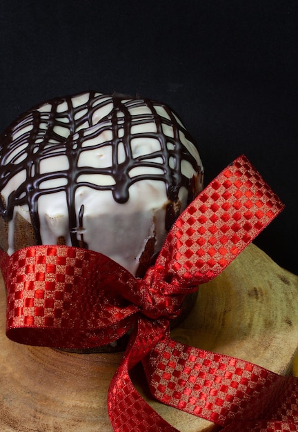 Panettone over een houten bureau met een rode stropdas met een zwarte achtergrond