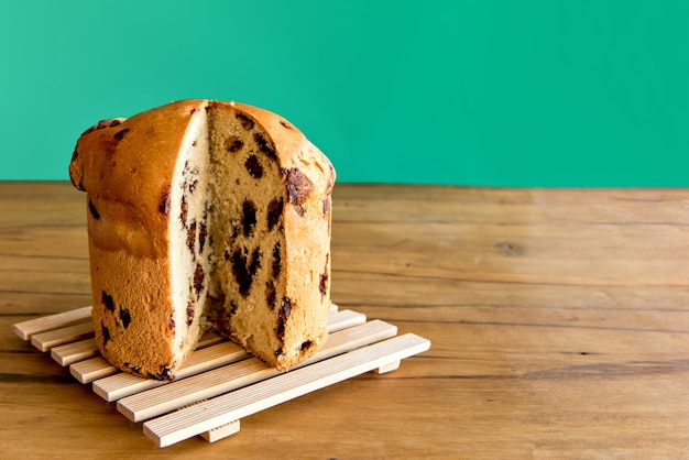 Panettone uitgesneden op groene achtergrond. Kerst dessert.