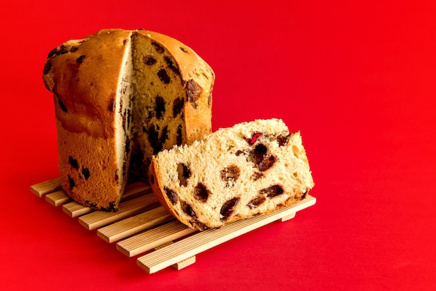 Panettone uitgesneden op rode achtergrond. Kerst dessert.