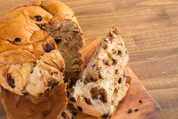 Panettone with chocolate on wooden table, traditional Italian dessert cake. Top view. Space for text.