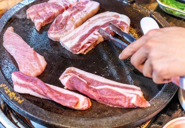 한국 레스토랑에서 튀긴 검은 돼지 고기 상추와 함께 철판에 신선한 맛있는 한국 음식은 복사 공간 라이프 스타일을 닫습니다