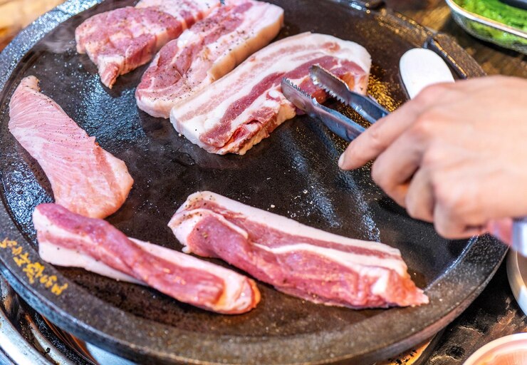 Photo 한국 레스토랑에서 튀긴 검은 돼지 고기 상추와 함께 철판에 신선한 맛있는 한국 음식은 복사 공간 라이프 스타일을 닫습니다
