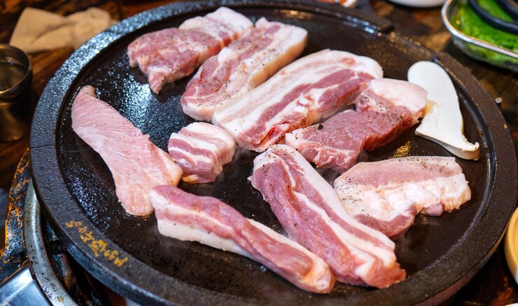 Photo 한국 레스토랑에서 튀긴 검은 돼지 고기 상추와 함께 철판에 신선한 맛있는 한국 음식은 복사 공간 라이프 스타일을 닫습니다