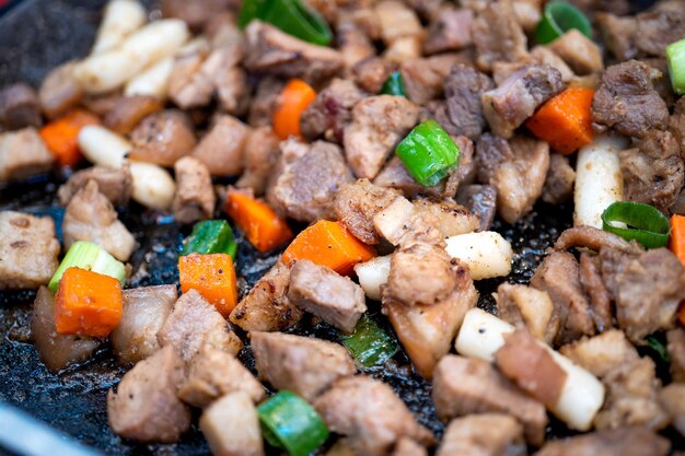 한국 전통 시장에서 Panfried 검은 돼지 고기 식사 당근과 샬롯 파와 함께 맛있는 한국 음식 요리 복사 공간을 닫습니다