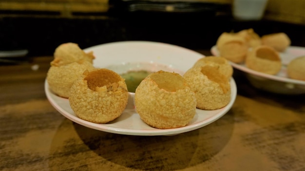 Photo pani puri or golgappa or puchkas from a white plate