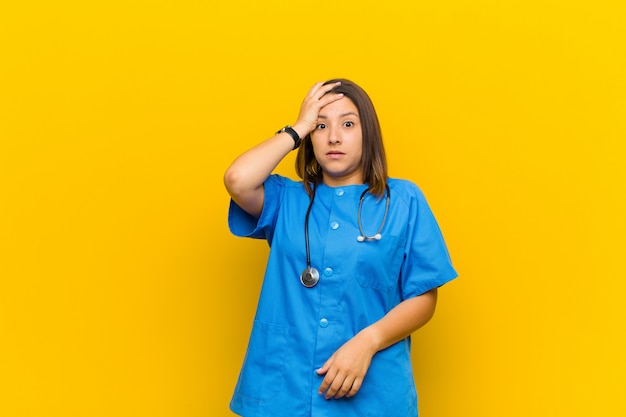 Photo panicking over a forgotten deadline, feeling stressed, having to cover up a mess or mistake isolated against yellow wall