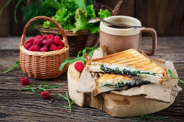 Panini sandwich with cheese and mustard leaves. Morning coffee. Village breakfast