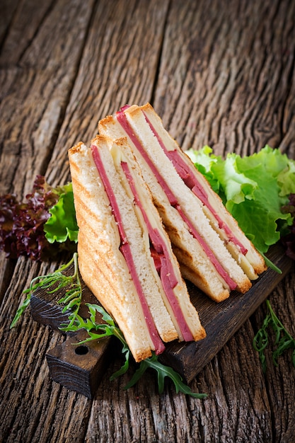 panini with ham and cheese on wooden table