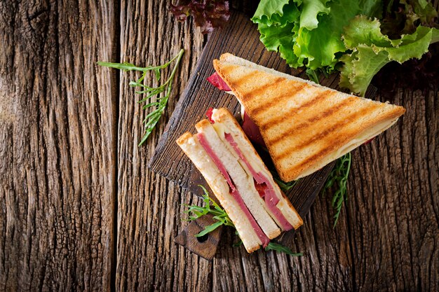panini with ham and cheese on wooden table