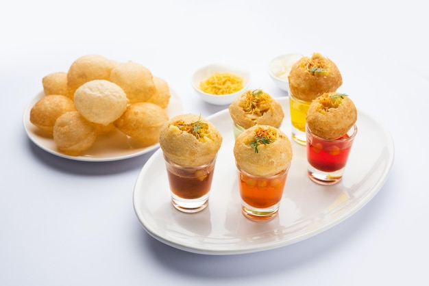 Panipuri Shot или Golgappa Shots с водой разных вкусов, подаваемой в маленьких стаканах с индийской закуской из пури с начинкой