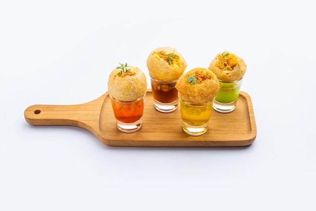 Panipuri Shot или Golgappa Shots с водой разных вкусов, подаваемой в маленьких стаканах с индийской закуской из пури с начинкой