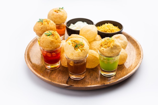 Panipuri Shot или Golgappa Shots с водой разных вкусов, подаваемой в маленьких стаканах с индийской закуской из пури с начинкой