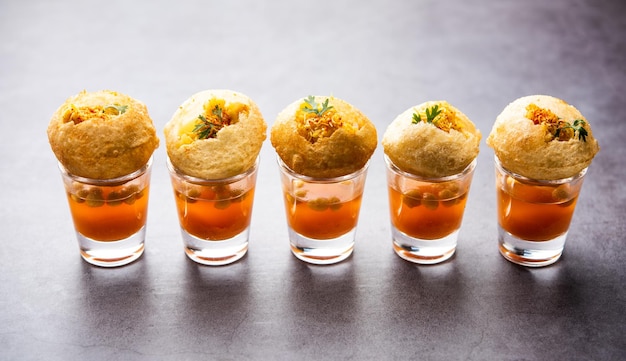 Panipuri shot or Golgappa Shots different flavours of water served in small glasses with stuffed puri Indian starter snack