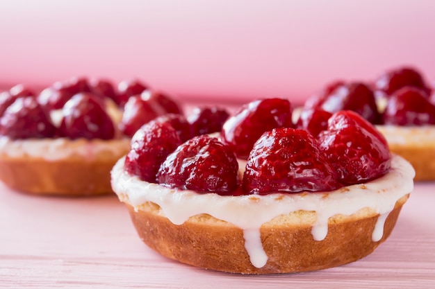 Foto torte di panna cotta con frutti di bosco su uno sfondo di legno rosa