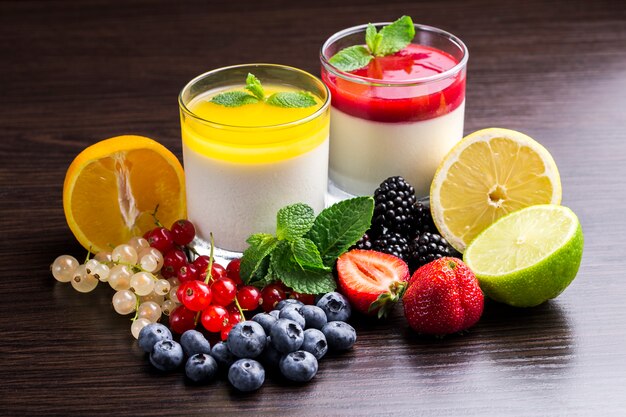 Panna cotta dessert in a glass container and fruit