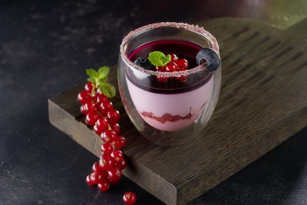 Panna cotta dessert in a glass on rustic wooden table.