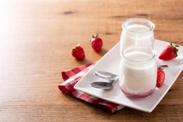 Panna cotta dessert with strawberry on wooden table