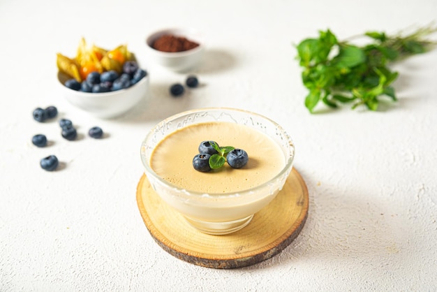 Panna cotta met bosbessen en munt op een witte achtergrond