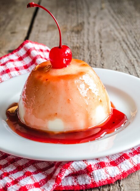 Panna cotta with berry sauce and maraschino cherry