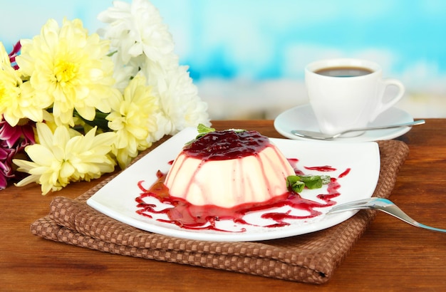 Panna Cotta with raspberry sauce on bright background