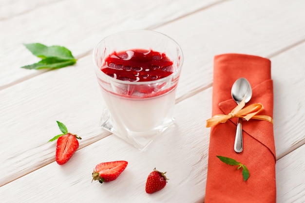 Panna cotta with strawberry on wooden desk