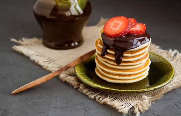 Pannekoeken met chocolade op een grijze achtergrond.