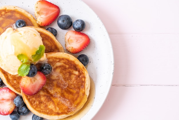 Pannenkoek met bosbessen, aardbeien, honing en vanille-ijs