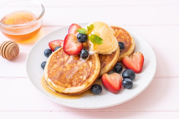 pannenkoek met bosbessen, aardbeien, honing en vanille-ijs