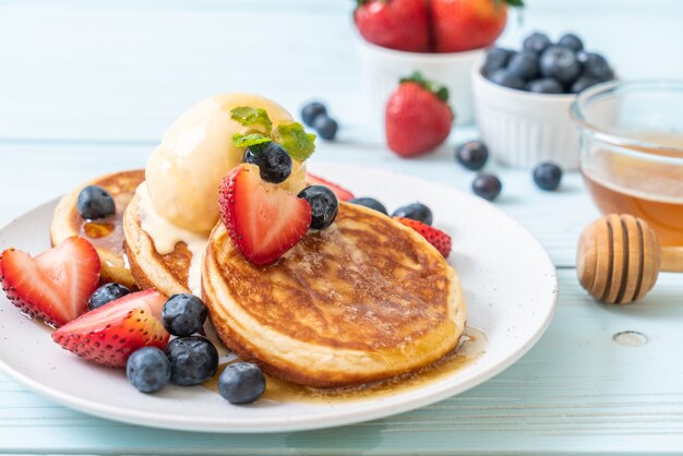 Pannenkoek met bosbessen, aardbeien, honing en vanille-ijs