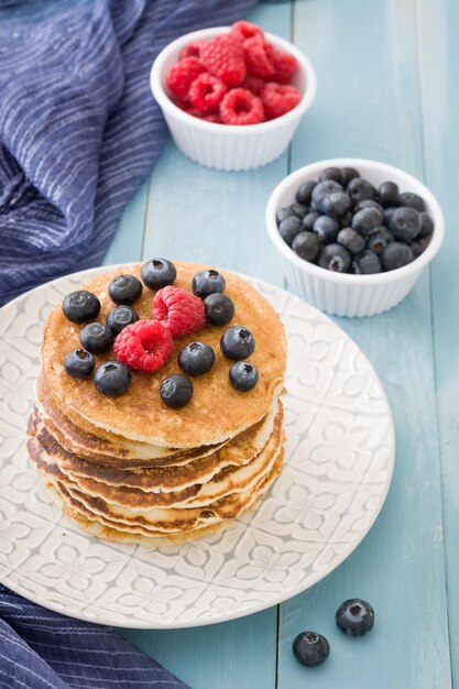 Pannenkoek met bosbessen en frambozen op blauwe houten tafel