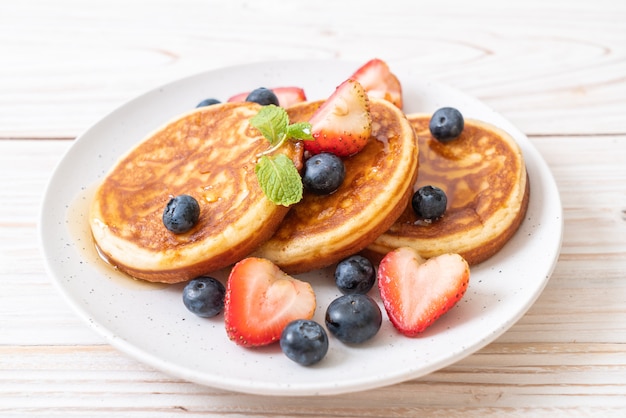 pannenkoek met verse bosbessen, verse aardbeien en honing