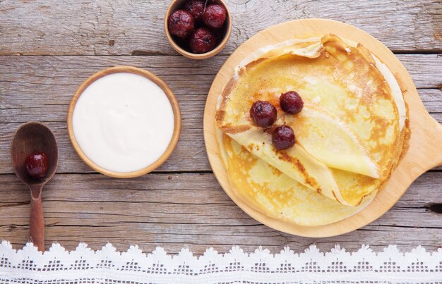 Pannenkoeken (Blini) en Honing op houten achtergrond, bovenaanzicht, kopie ruimte. Zelfgemaakte dunne pannenkoeken voor ontbijt of dessert.